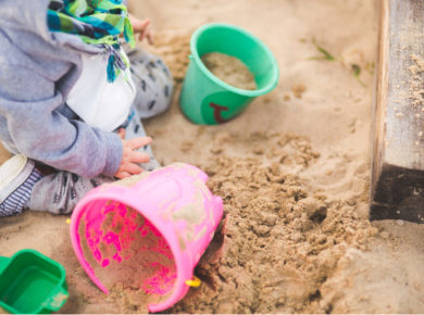 Spielende Kinder sollten im Sandkasten vor der Sonne geschützt werden.